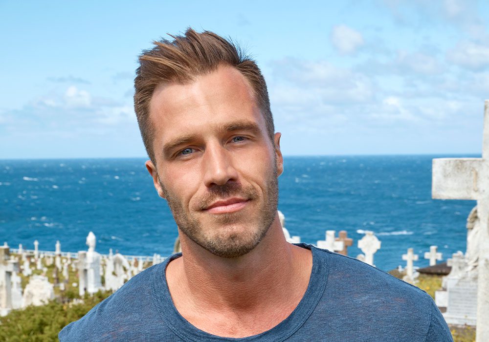 Author Reece Carter standing on a hill with the ocean in the background